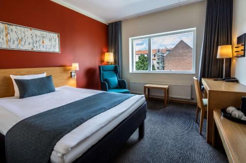 奥尔堡奥尔堡市斯堪迪克酒店的配有一张床、一张书桌和一扇窗户的酒店客房