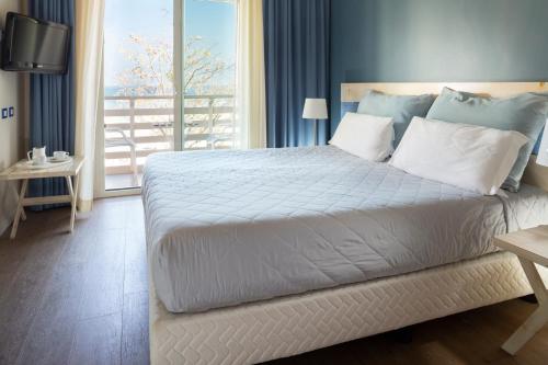 里米尼拉蒙萝莎酒店的卧室设有一张大白色床和阳台
