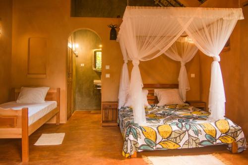 圣玛丽Villa Paradis的一间卧室配有两张床和一张天蓬床。