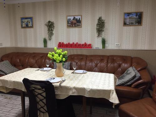 新切尔卡斯克Гостевой дом ДАЧА的客厅配有桌子和真皮沙发