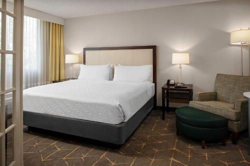 皮博迪波士顿皮博迪假日套房酒店的配有一张床和一把椅子的酒店客房