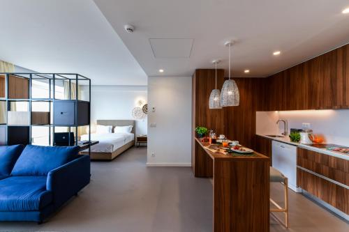 里斯本Oscar Concept Apartments的客厅和带蓝色沙发的厨房