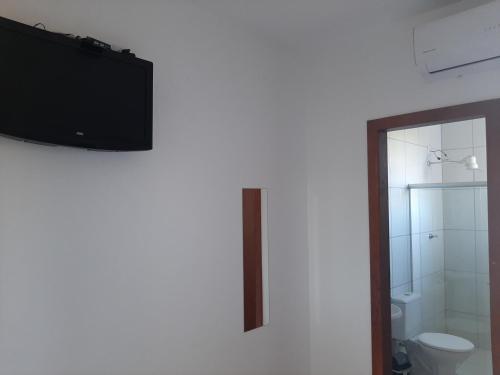 塞拉Pousada do caju的一间带卫生间的浴室和墙上的电视