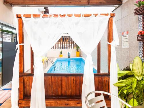 阿拉亚尔达茹达Pousada Recanto do Mucugê的小型游泳池配有白色的淋浴帘