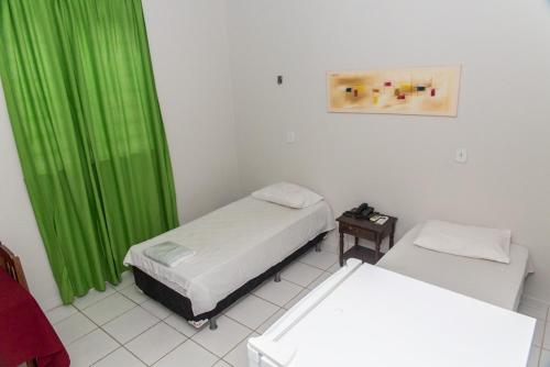 博阿维斯塔尤泽比奥酒店的一间设有两张床和绿帘的房间