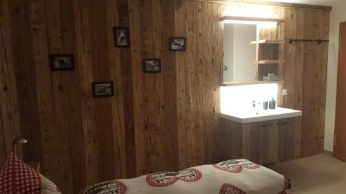 阿罗萨Chalet Waldperle的一间卧室设有一面带镜子的木墙和一张床
