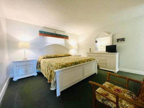 克利尔沃特Holiday Villas III的一间卧室配有一张床、镜子和椅子