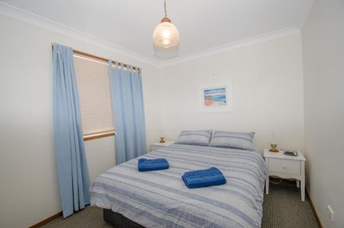 凯阿玛Kiama Coastal Escape的一间卧室配有一张带蓝色枕头的床。
