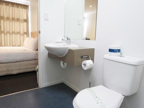 奥克兰Tetra Serviced Apartments by Castle的一间带卫生间、水槽和床的浴室
