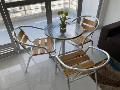 吉拉尔多特Acogedor apartamento en Girardot, fresco y tranquilo的一张带两把椅子的玻璃桌和盆栽植物