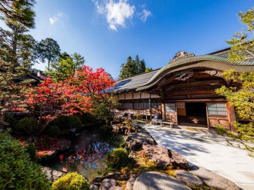 高野山高野山 宿坊 恵光院 -Koyasan Syukubo Ekoin Temple-的前面有池塘的建筑