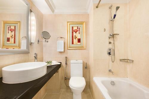 卡拉奇Ramada Plaza by Wyndham Karachi Airport Hotel的浴室配有盥洗盆、卫生间和浴缸。