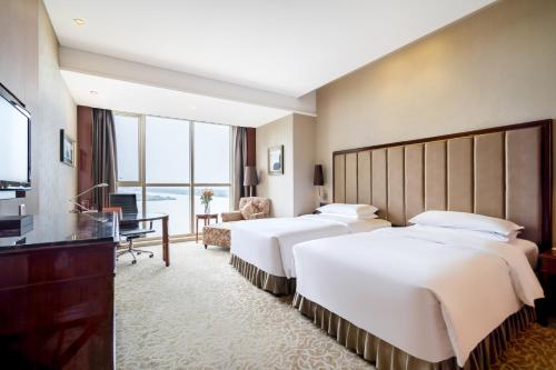 镇江镇江兆和皇冠假日酒店的酒店客房设有两张床和电视。