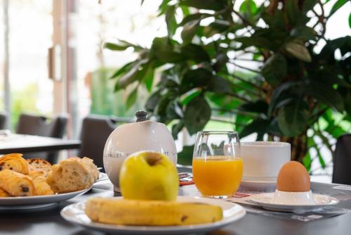 凯恩Zenith Hotel Caen的一张桌子,上面放着一盘食物和一杯橙汁