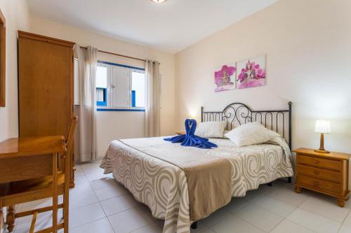 塞博河畔卡莱塔El Sombrerito 4的一间卧室配有一张带蓝色丝带的床