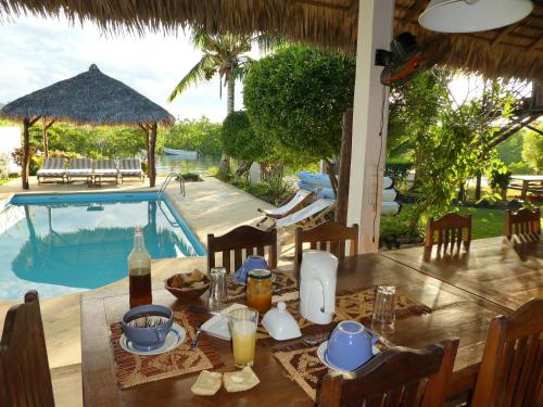 安迪拉纳2 bedrooms bungalow with sea view shared pool and enclosed garden at Andilana的游泳池旁的餐桌上摆放着食物和饮料