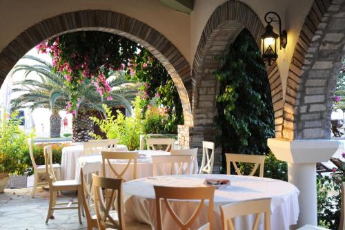 皮加迪卡Assa Maris Beach Hotel的户外庭院配有白色的桌椅。