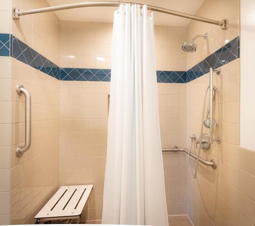 圣克拉拉格拉纳达旅馆的一间带白色淋浴帘的浴室