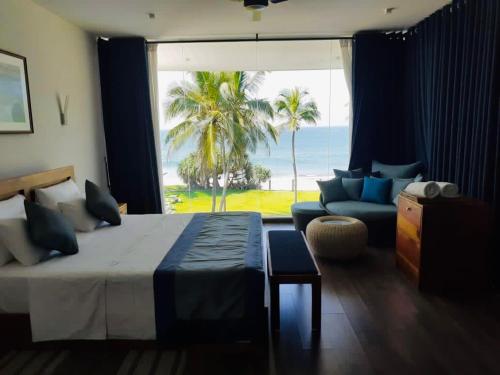 尼甘布The Lighthouse Negombo的一间卧室配有一张床,享有海景