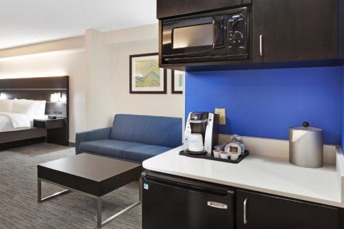 库尔佩珀Holiday Inn Express & Suites Culpeper, an IHG Hotel的酒店客房设有厨房和客厅。