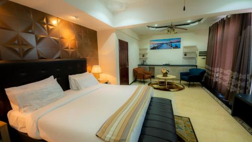 达累斯萨拉姆马缨丹酒店 的一间卧室设有一张床和一间客厅。