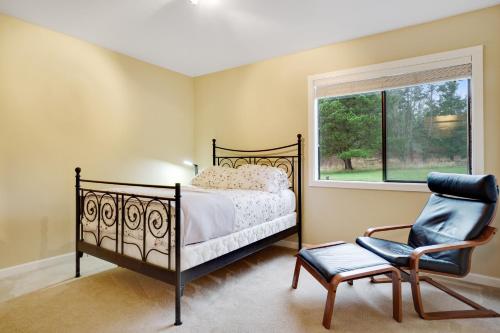 LopezFisherman Bay Beach House的卧室配有床、椅子和窗户。