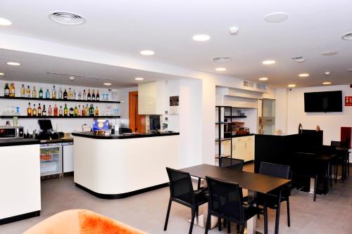 卡斯特尔德费尔斯6 Bis HOTEL的餐厅设有酒吧、桌子和椅子