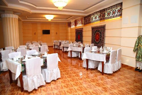 撒马尔罕撒马尔罕梦想酒店 的宴会厅配有白色的桌子和白色的椅子