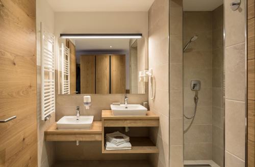 维皮泰诺Hotel Restaurant Schaurhof的一间带两个盥洗盆和淋浴的浴室
