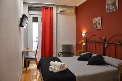 马德里阿雷索尔旅馆的一间卧室设有两张床和红色窗帘