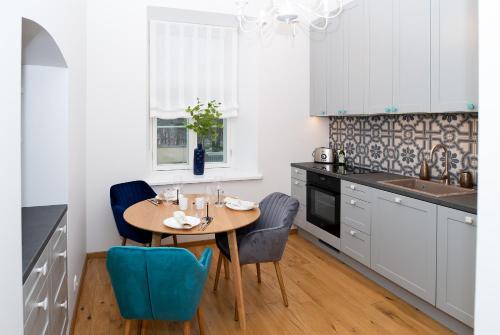 塔尔图Lossi 32 Luxury Apartment with Sauna的厨房配有木桌和蓝色椅子