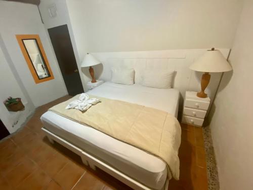坎昆Casa CARIBE Cancun的一间卧室配有一张带两盏灯的大型白色床。