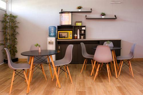 莱昂Suites Bajío的一间带2张桌子和椅子的用餐室