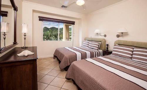 赫拉多拉Ocean View Condo in Los Sueños的酒店客房设有两张床和窗户。