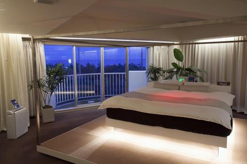 大洗町Hotel Oarai Seven Seas(Adult Only)的一间带大床的卧室和一个阳台
