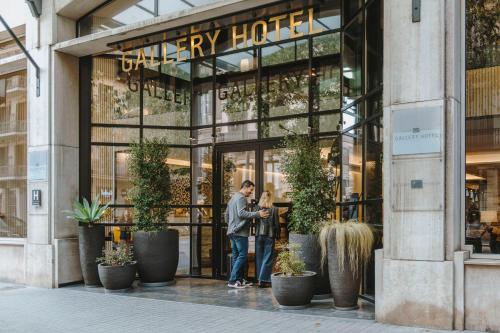 巴塞罗那Gallery Hotel 4 Sup的一对夫妇站在城市酒店前