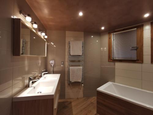 谷雪维尔Chalet Emilie的浴室配有盥洗盆和浴缸。