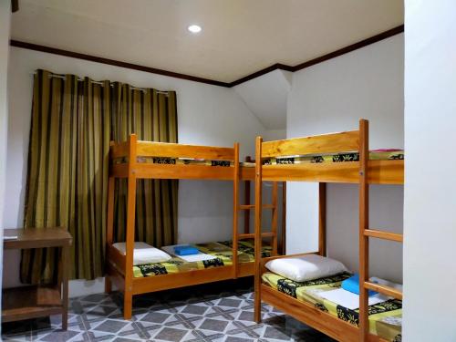 莫阿尔博阿Pacifico Seaside Lodge的客房设有三张双层床和一张书桌。