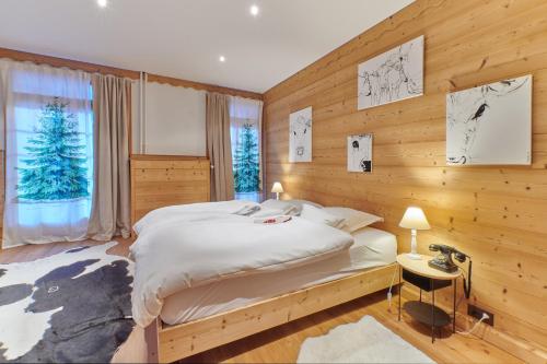 尚佩里Boutique Hotel Beau-Séjour & Spa Superior的一间卧室设有一张床和木墙