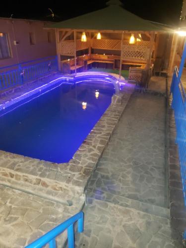 圣佩德罗·德·阿塔卡马Hostal Illauca de Atacama的后院的游泳池,晚上有蓝色的灯光