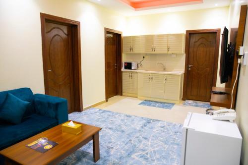哈费尔巴廷فندق بــــاســــيل的一间带蓝色沙发的客厅和一间厨房