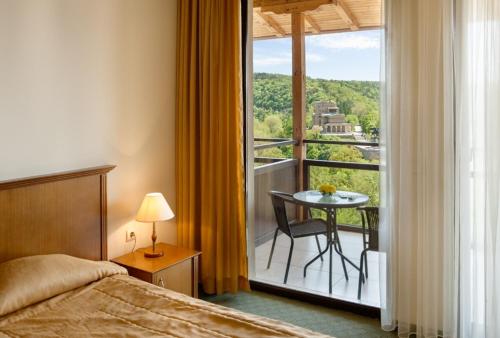 大特尔诺沃全景酒店的一间卧室配有一张床,阳台配有桌子