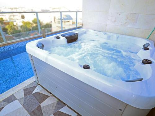 内坦亚Luxury Rooftop Apartment in Netanya的浴室内设有装满水的白色浴缸。