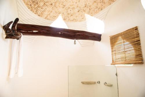 安赫尔港Hotel Pasión de Luna的挂在浴室天花板上的树枝