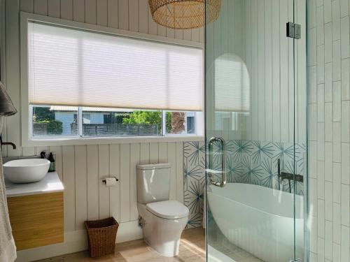 拉塞尔9 The Strand的浴室配有卫生间、浴缸和水槽。