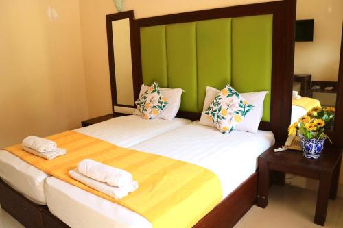 巴加滨江度假城 的绿墙客房中的两张单人床