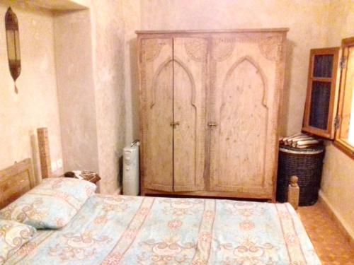 拉巴特3 bedrooms house at Rabat 800 m away from the beach with furnished terrace的一间卧室配有一张床和一个大型木制橱柜