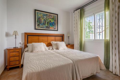 阿尔姆尼卡4 bedrooms house at Almunecar 400 m away from the beach with sea view private pool and furnished terrace的一间卧室设有一张大床和一个窗户。