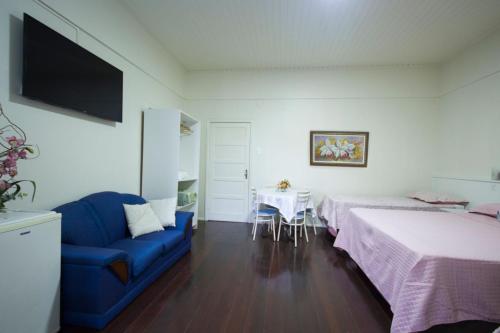 布卢梅瑙15号酒店的一间卧室配有两张床、一张蓝色的沙发和一张桌子