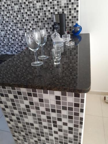 玛丽亚法里尼亚Apartamento Maria Farinha的浴室的柜台上摆放着三杯酒杯